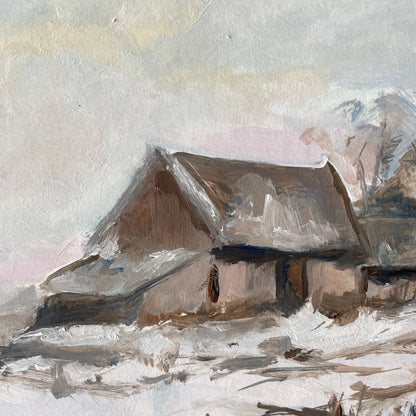 close up of a solitary norfolk home on a snowy day with hints of colourin the sky 