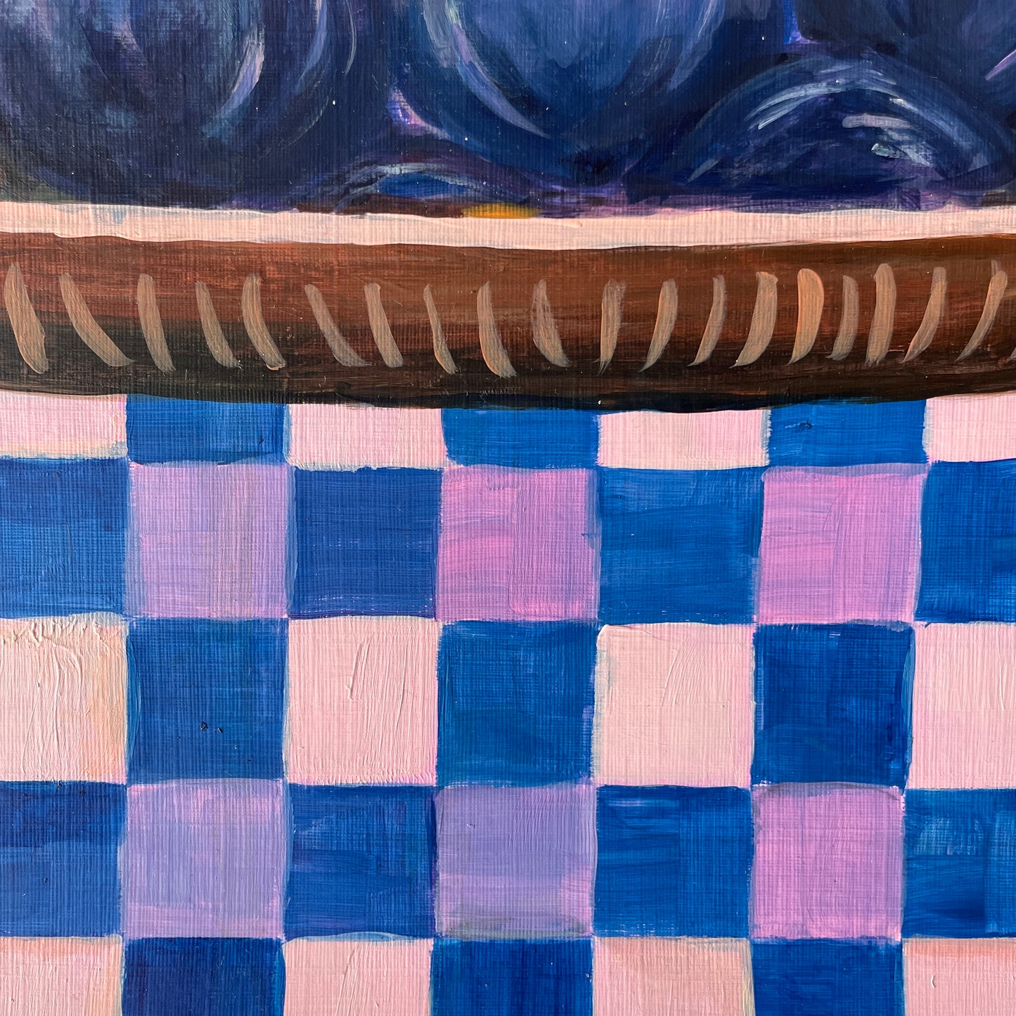 Wooden dish on a checkered fabric background with blue and pink squares