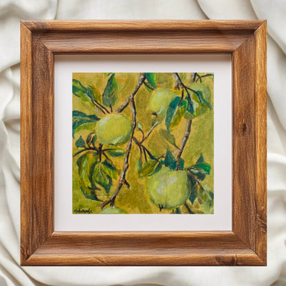 Framed artwork of green fruit on a branch with leaves painted by emerging artist halima khanum